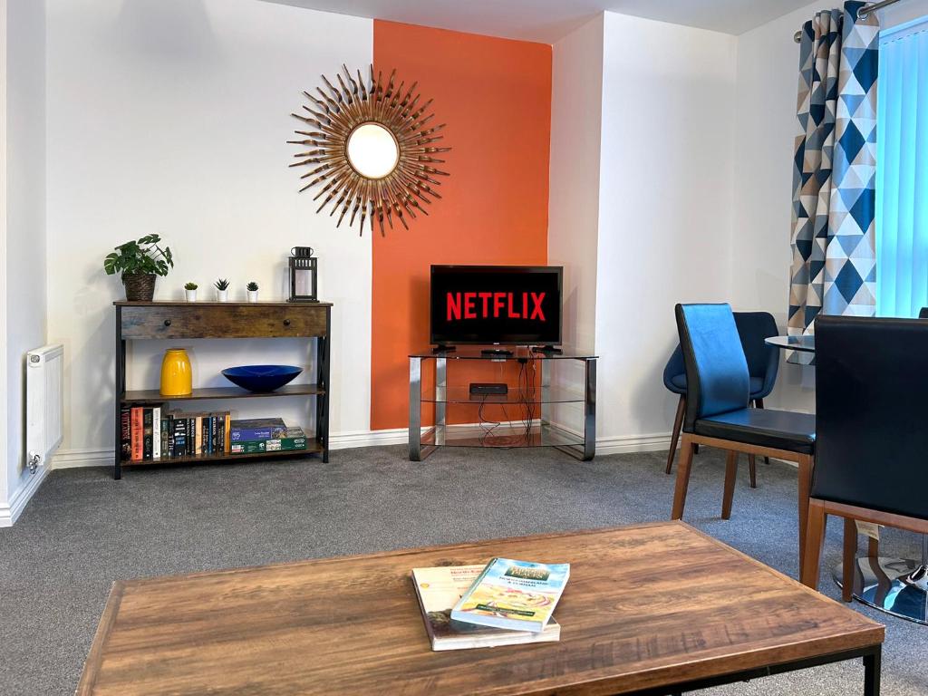 a living room with a table and a tv at Hindmarsh Apartment in Ashington
