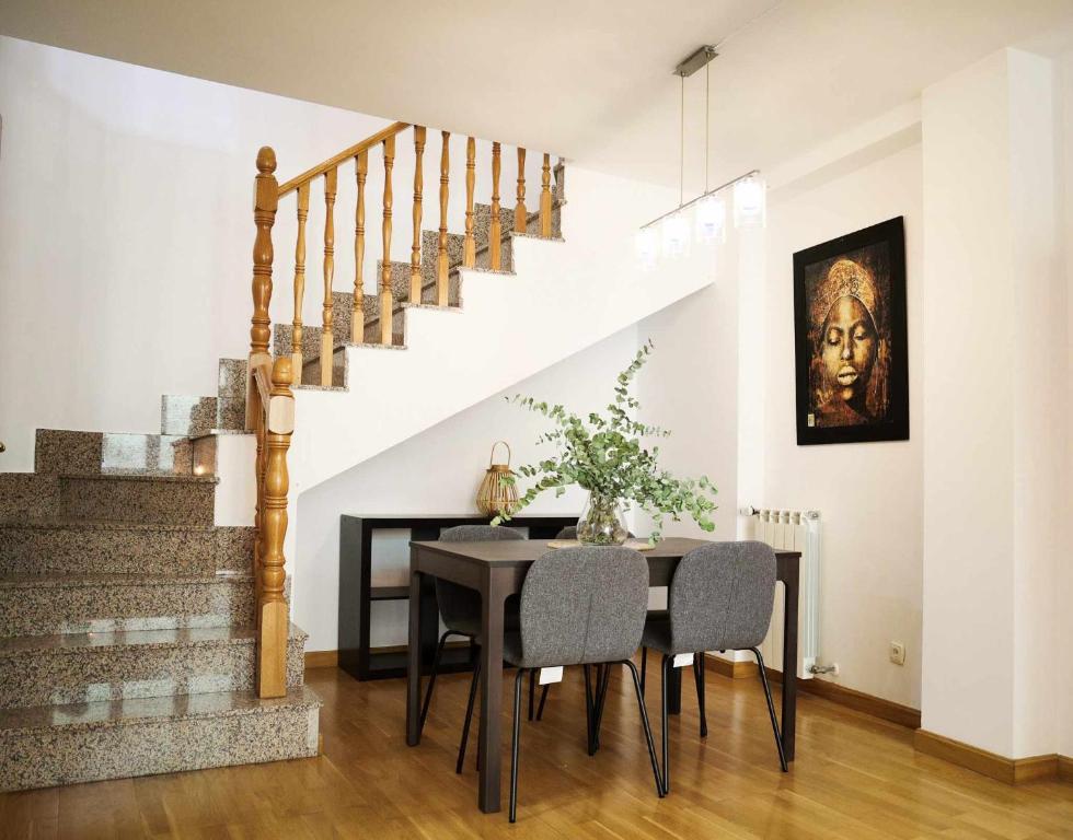 a dining room with a table and a staircase at 33 Pasos Catedral 2 in León