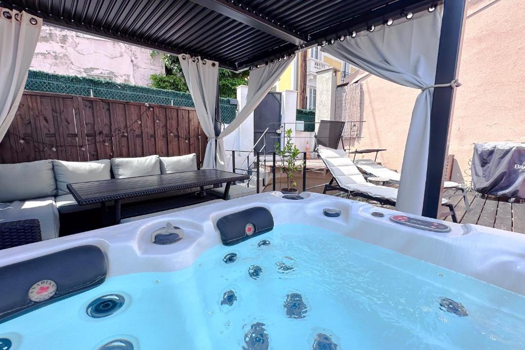 un bain à remous installé sur une terrasse avec un banc dans l'établissement BELLET - Rooftop, jacuzzi et vue imprenable sur Nice et Mer, à Nice