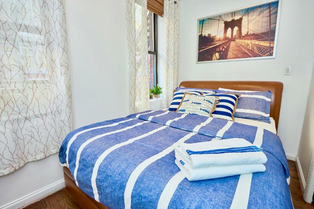 - une chambre avec un lit bleu et blanc et des serviettes dans l'établissement Cozy FamilyFriendly Apartment with 2 Bedrooms, à New York