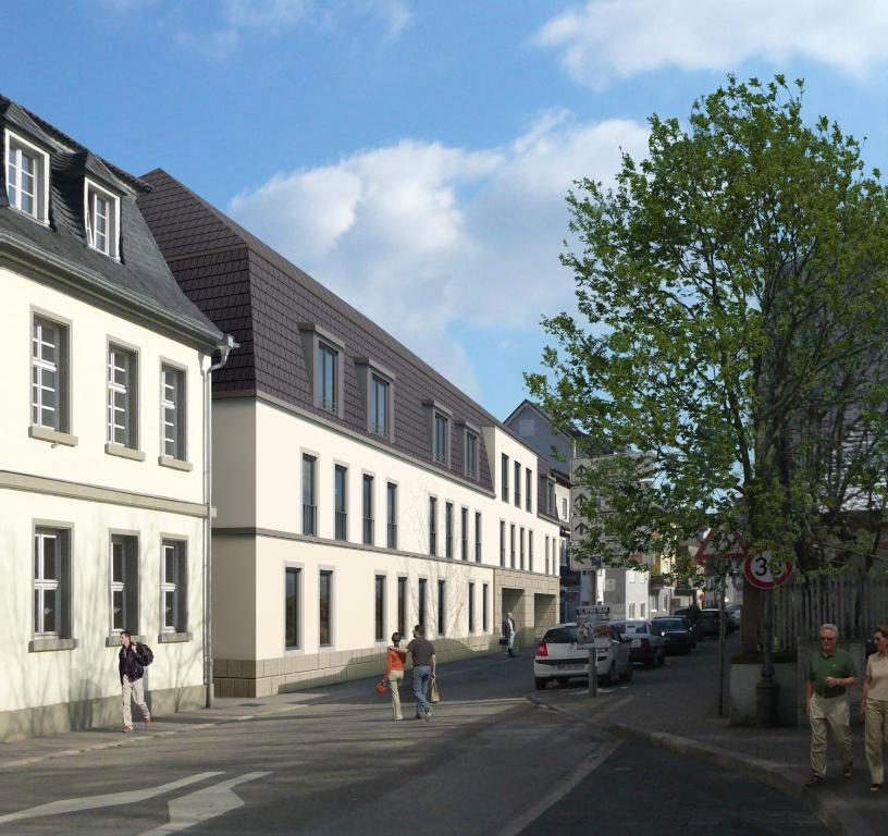 een groep mensen die in een straat naast gebouwen lopen bij Gästehaus am Schloss in Schwetzingen