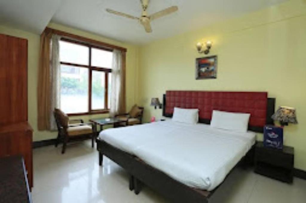 um quarto com uma cama grande e uma cabeceira vermelha em Goroomgo D2 Holiday inn Near Sea Beach em Puri