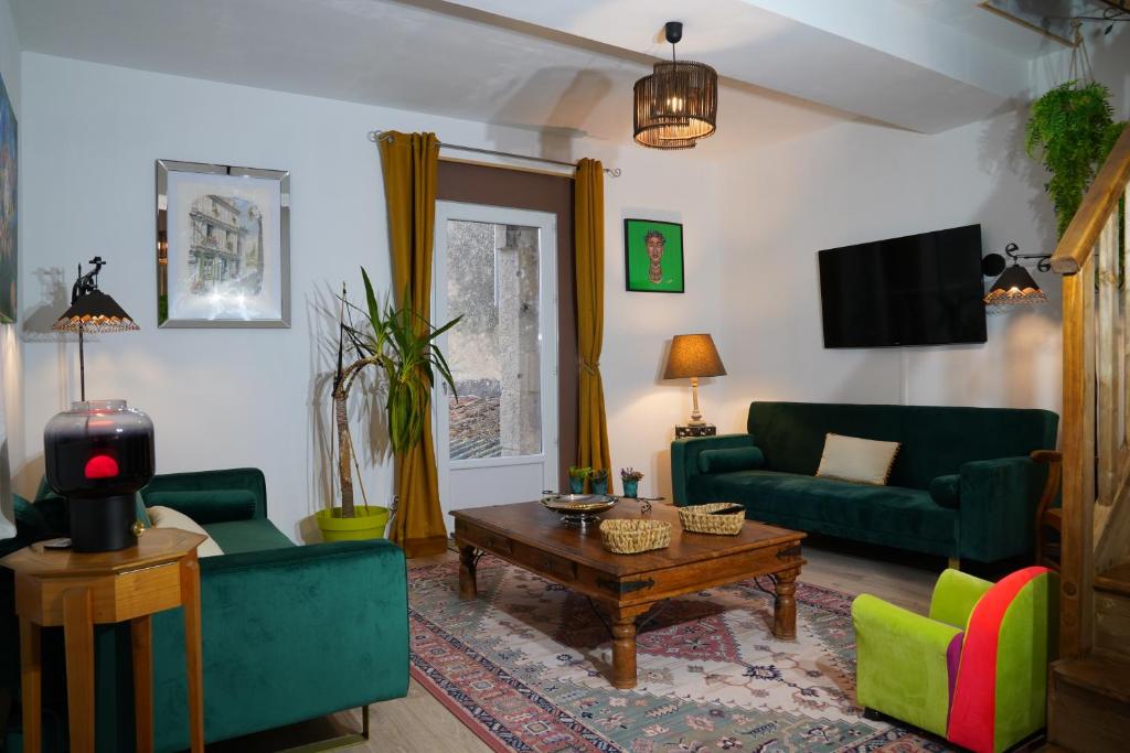 a living room with green couches and a coffee table at la roseraie in Saint Loup Lamaire