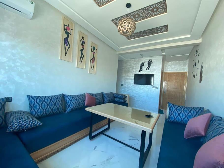 uma sala de estar com um sofá azul e uma mesa em Holikeys - Fès - 3 Ch - Lot Brdai 003 em Fez