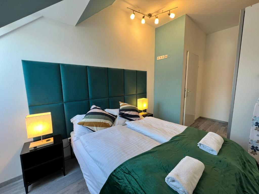 a bedroom with a large bed with a green headboard at Elegant 2+1 BR Apt at Vienna's Vibrant 3. District in Vienna