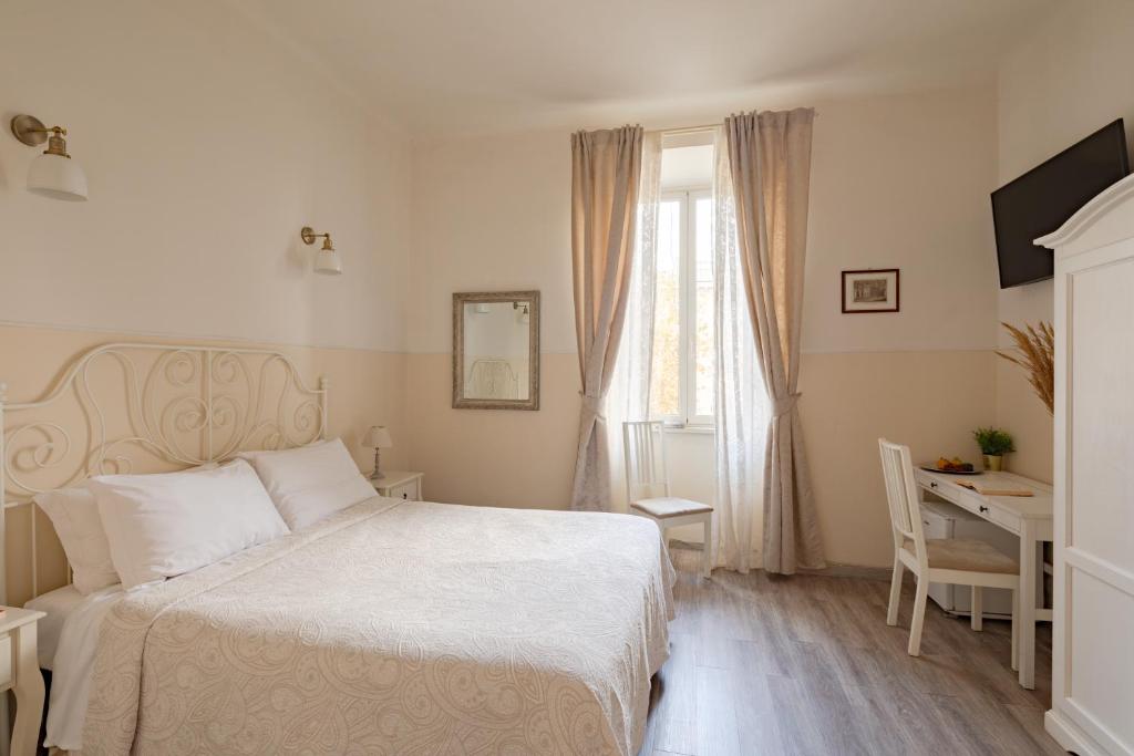 1 dormitorio con cama, escritorio y ventana en Dante's in Vaticano 2 en Roma