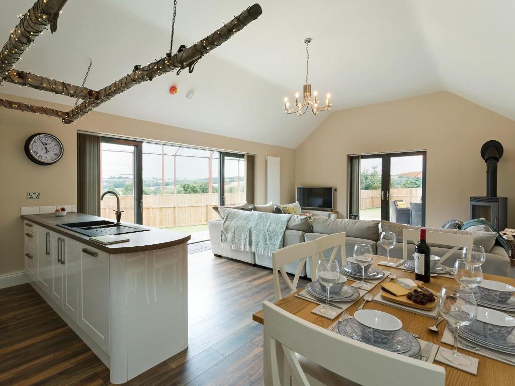 a kitchen and living room with a couch and a table at The Cart Shed in Witton Gilbert