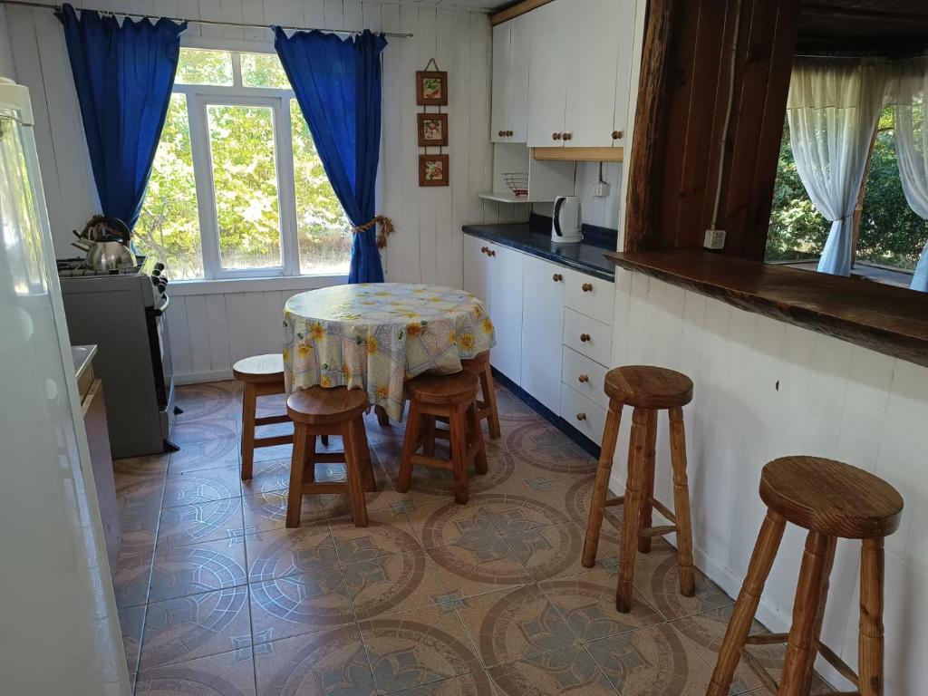 a kitchen with a table and stools in it at Arriendo casa Verano Pucón in Pucón