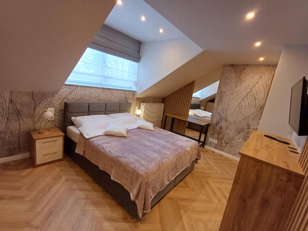 a bedroom with a large bed and a large window at Apartamenty u Roxi in Jelenia Góra