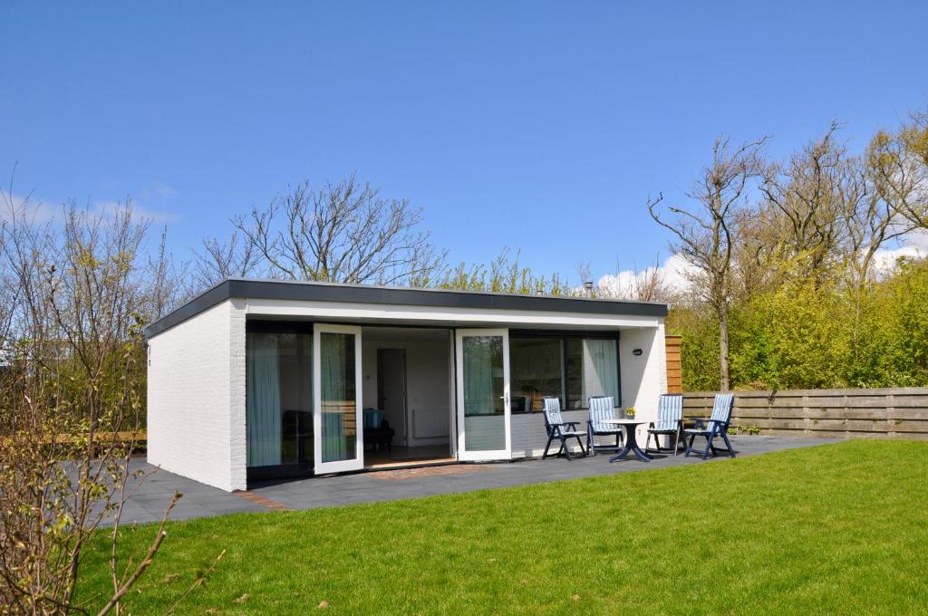 een modulair huis met een patio en gras bij Garnekuul 72 in Callantsoog