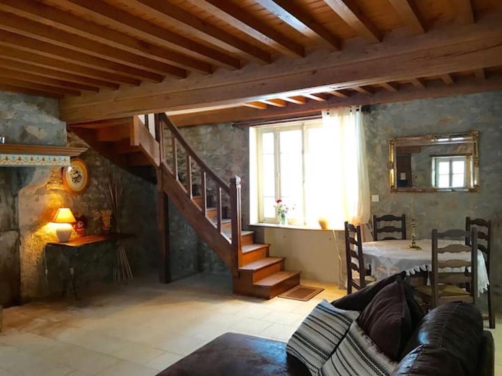 a living room with a staircase in a house at Morvan La Pastourelle in Quarré-les-Tombes