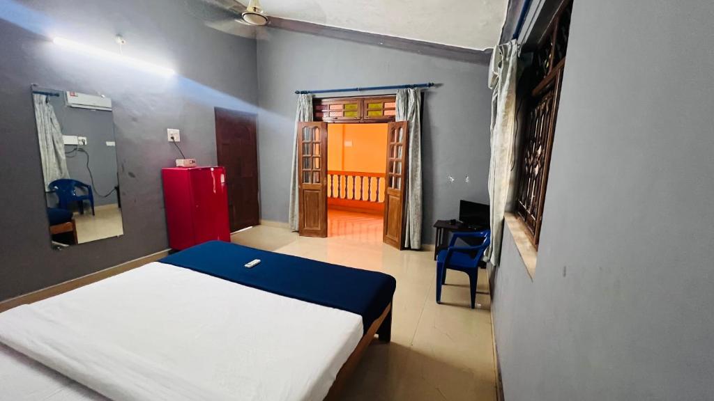 a bedroom with a bed and a red refrigerator at HARSH ANGEL HOLIDAY HOMES in Calangute