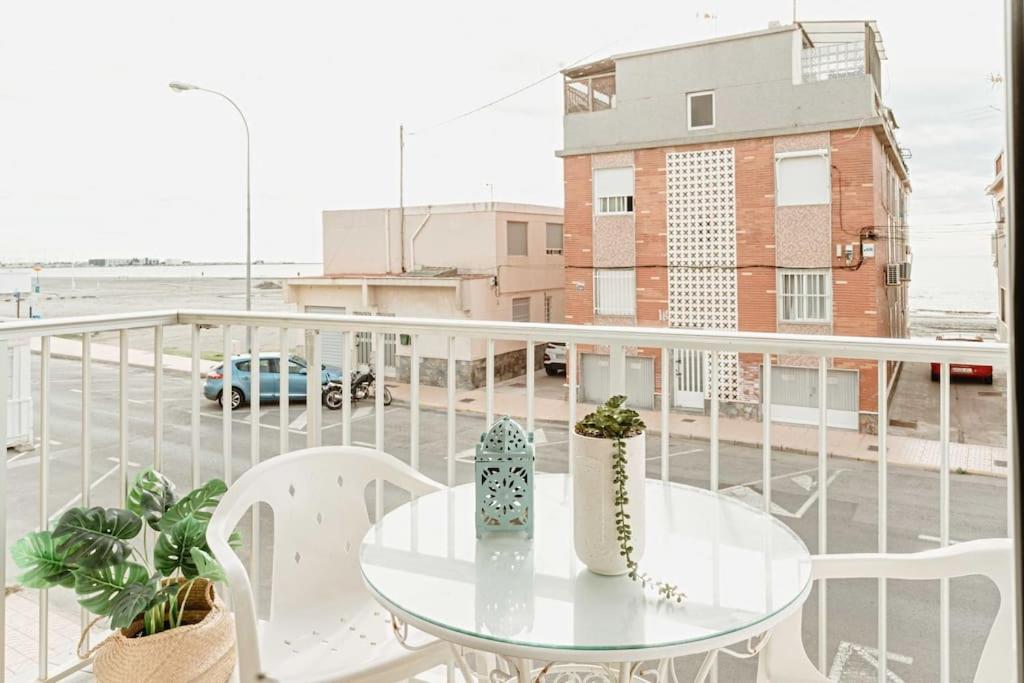 uma mesa numa varanda com vista para um parque de estacionamento em Apartamento frente al mar, familiar y acogedor. em Santa Pola
