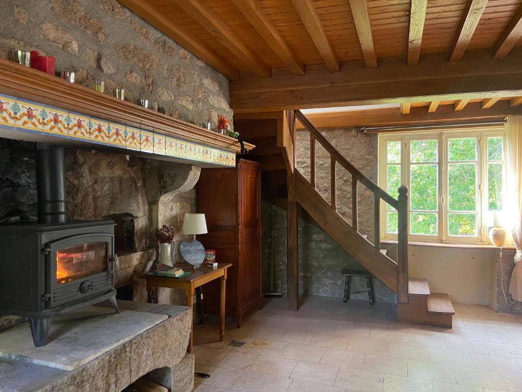 a living room with a fireplace and a staircase at Morvan La Pastourelle in Quarré-les-Tombes