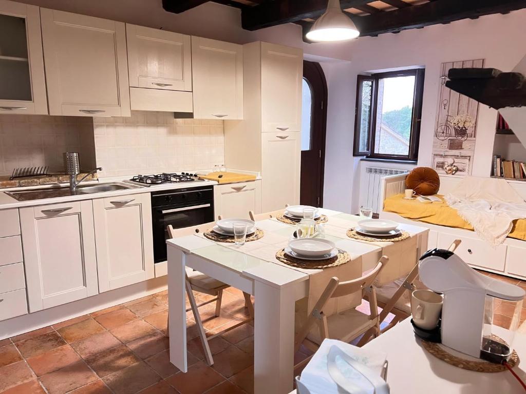 een keuken met witte kasten en een tafel met borden erop bij Castelvecchio 160 in Sarnano