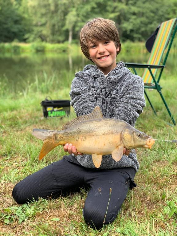 a young boy holding a fish in his hands at Morvan La Pastourelle in Quarré-les-Tombes