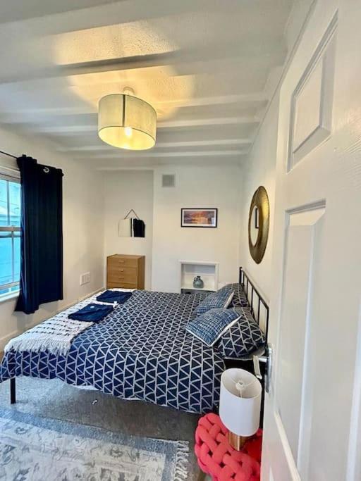 a bedroom with a blue and white bed in it at Saxon Cottage St Leonards on sea in Hastings
