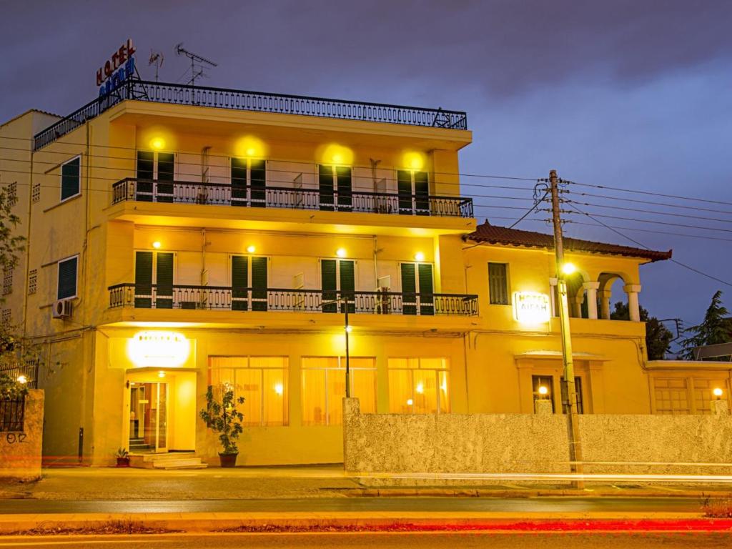 ein großes gelbes Gebäude mit Balkon in der Nacht in der Unterkunft Aegli Hotel in Athen