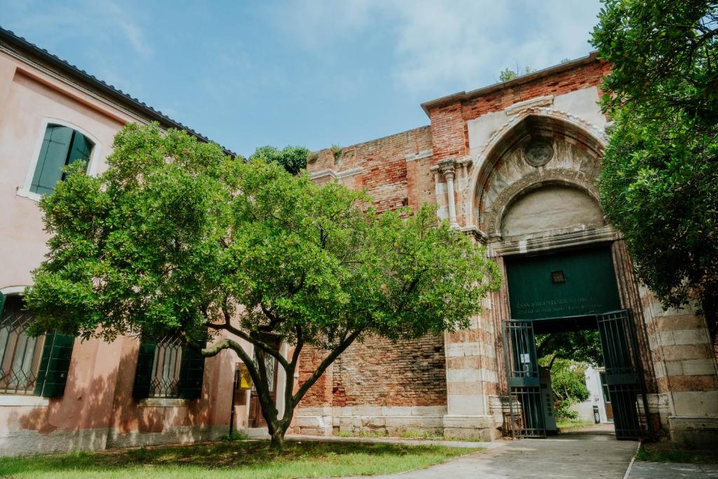 an old brick building with a tree in front of it at Ostello S. Fosca - CPU Venice Hostels in Venice