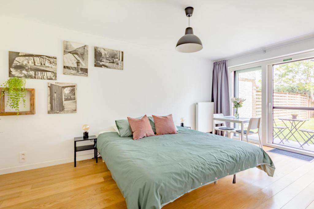 een witte slaapkamer met een bed en een tafel bij The Hadewijch - room nearby centre Bruges in Brugge