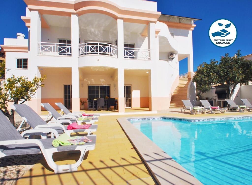 a villa with a swimming pool and a house at Villa Nespereira by Algarve Vacation in Albufeira