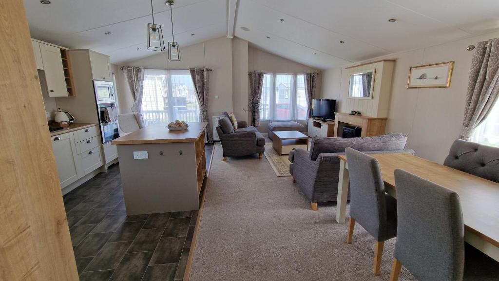 a kitchen and living room with chairs and a table at Camber Sands Holiday Park in Camber