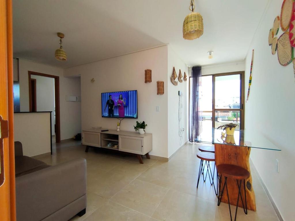 a living room with a couch and a tv on a wall at Nice apartment Bessa beach in João Pessoa