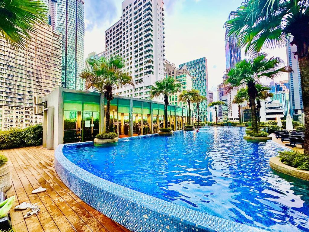 une grande piscine dans une ville avec de grands bâtiments dans l'établissement Around KLCC area vortex apartment, à Kuala Lumpur