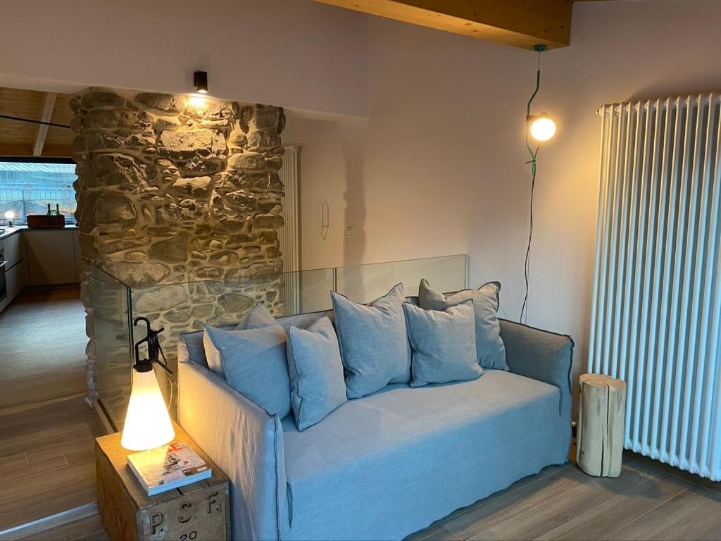ein Sofa mit blauen Kissen im Wohnzimmer in der Unterkunft Vicolo Rosso 2 in Dolceacqua