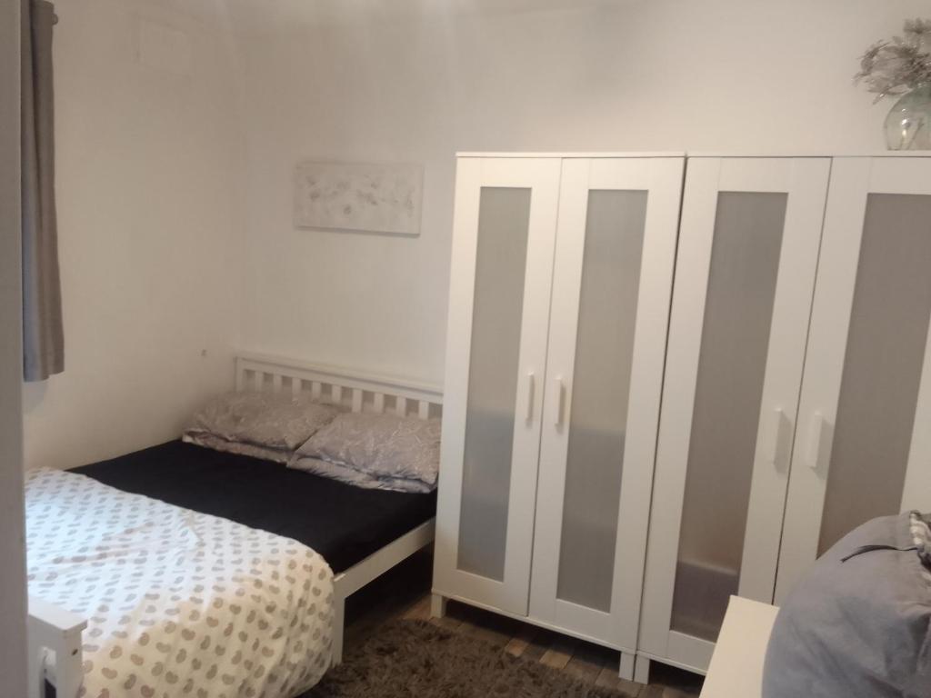 ein Schlafzimmer mit einem Bett und einem weißen Schrank in der Unterkunft Easy Stay in Streatham