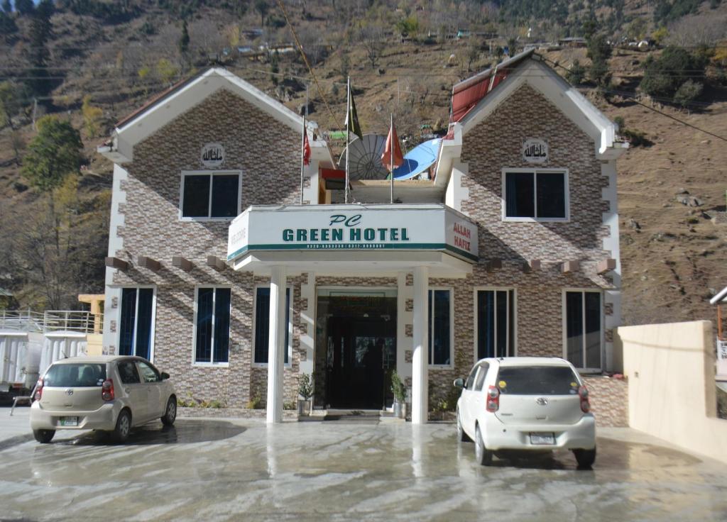 zwei Autos auf einem Parkplatz vor einem Gebäude geparkt in der Unterkunft PC Green Hotel, Mahandri, Kaghan in Mingora