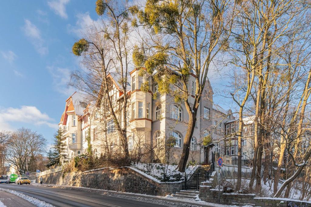 a large building on a street with snow on the ground at Downtown Apartments Sopot Chopina Seaside in Sopot