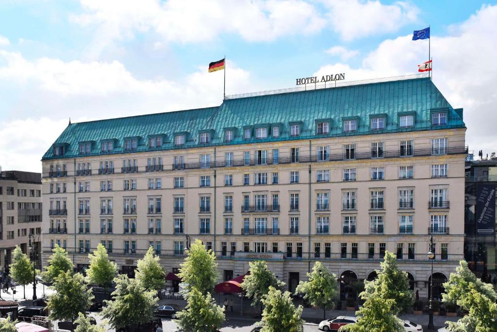 un edificio con due bandiere sopra di Hotel Adlon Kempinski Berlin a Berlino