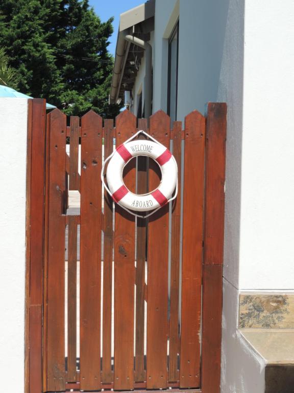 a wooden gate with a red and white life preserver on it at A Time And A Place in Plettenberg Bay