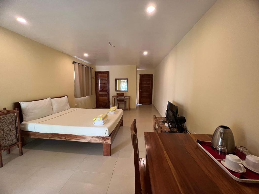Amor Double Room with Swimming Pool في بوراكاي: غرفة نوم بسرير وطاولة خشبية