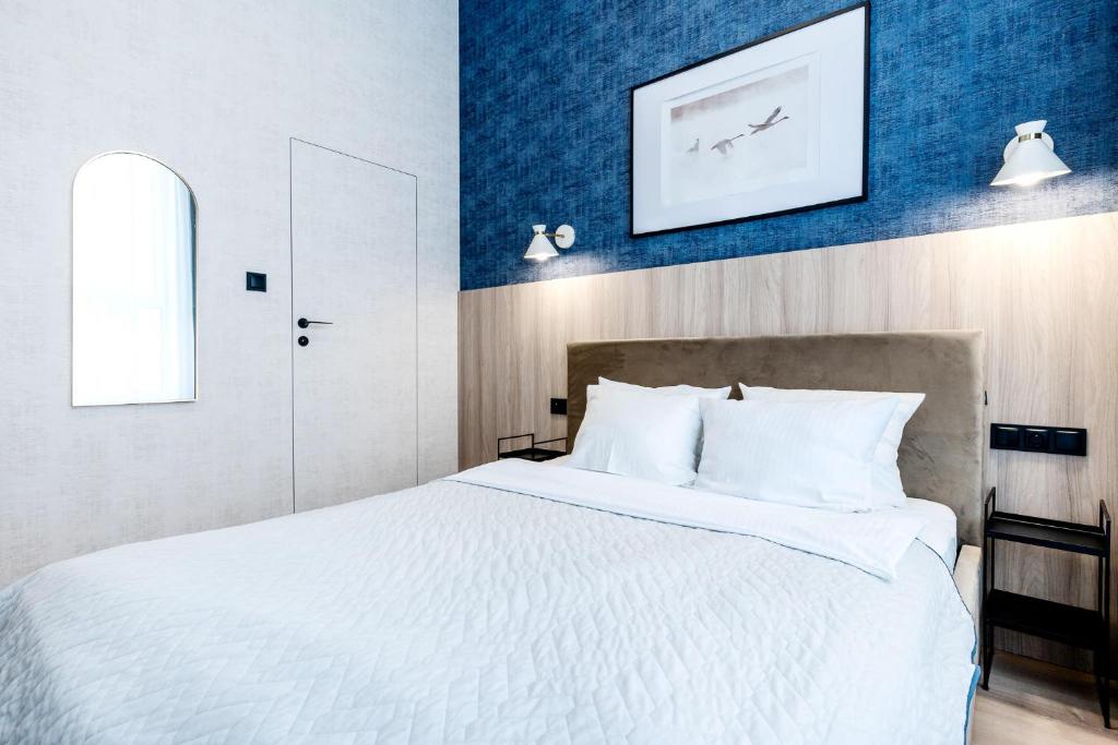 a bedroom with a large white bed with blue walls at Apartament UKIEL PARK 39 przy Plaży Miejskiej - klimatyzacja,free parking,FV in Olsztyn