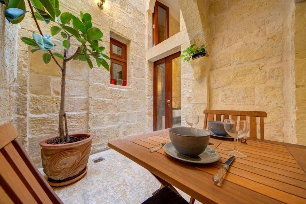 a wooden table with a potted plant on it at Quaint TownHouse in Cospicua in Cospicua