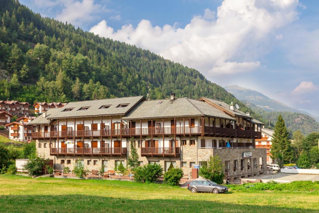 a large building in front of a mountain at Residence Stofol in Aprica