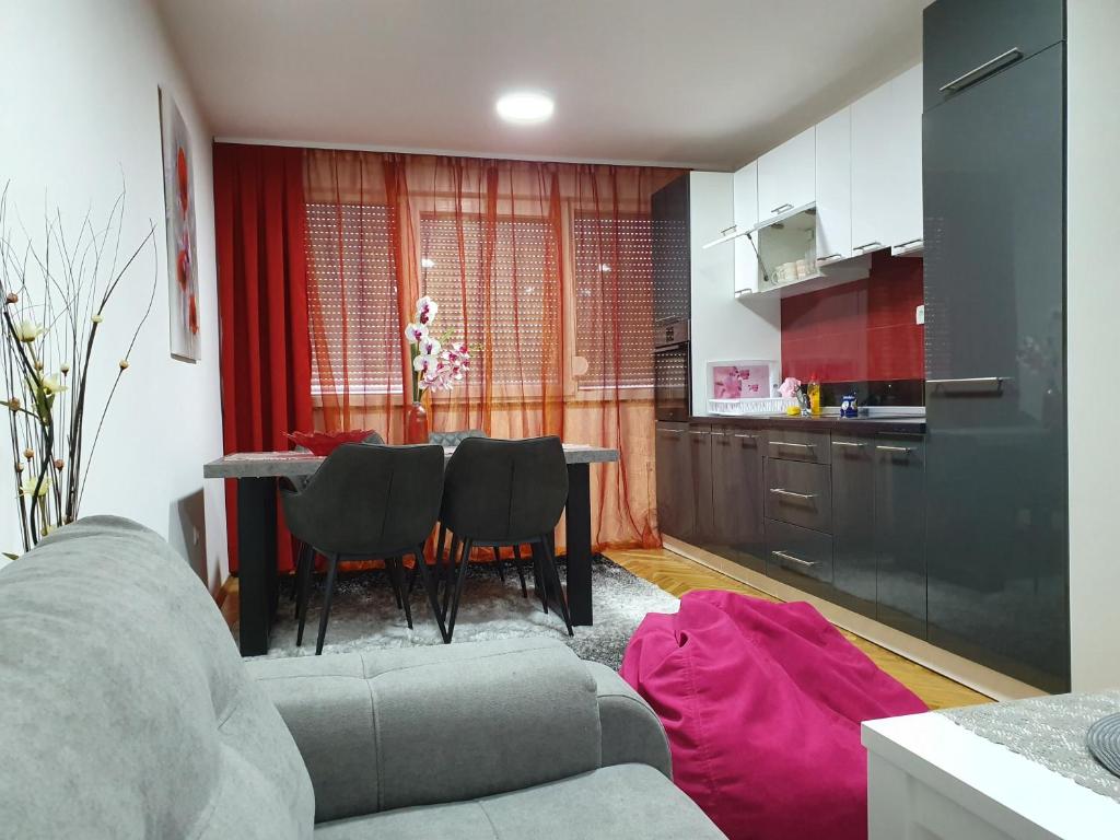 sala de estar con sofá y mesa con sillas en Apartment Centar with garage, en Velika Kladuša