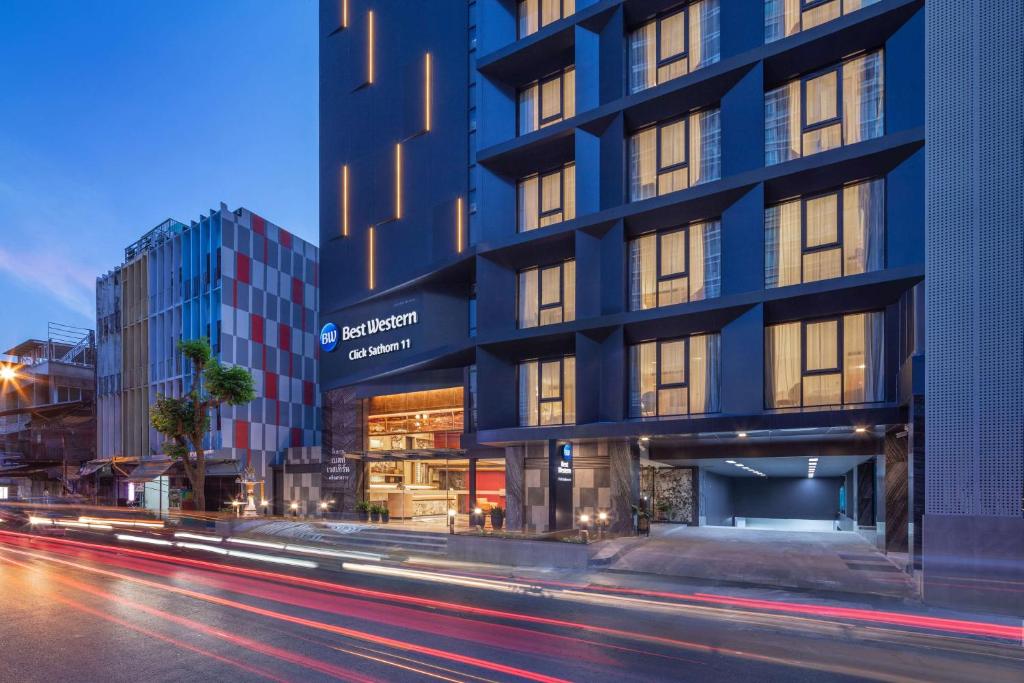 un edificio alto en una calle de la ciudad por la noche en Best Western Click Sathorn 11 Bangkok en Bangkok