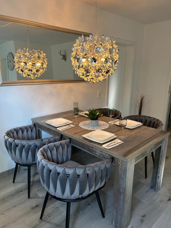 a dining room table with chairs and chandeliers at Ferienwohnung Trunk in Roschbach