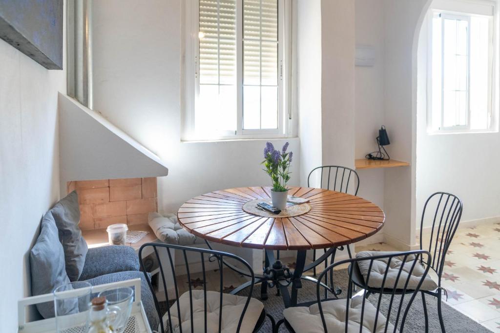 a dining room table with chairs and a table at Azafran Jerez apartamentos in Jerez de la Frontera