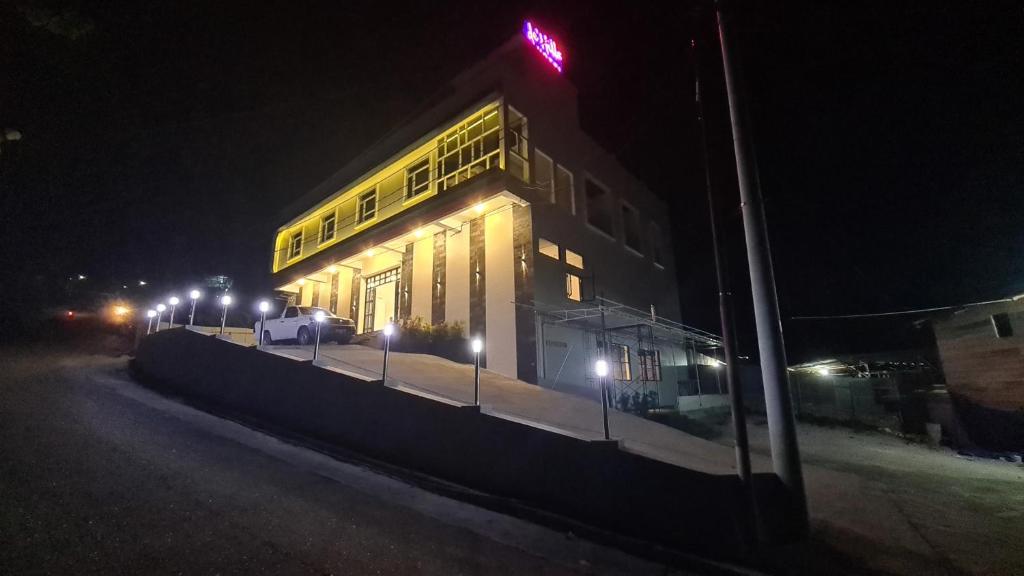 a large building with lights on the side of it at night at Dehills Hotel Luwuk in Luwuk