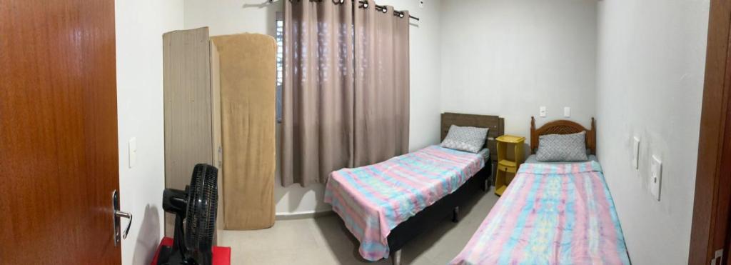 a bedroom with two twin beds and a crib at Casa Itajuba, Barra Velha, 20km do Beto Carrero in Barra Velha