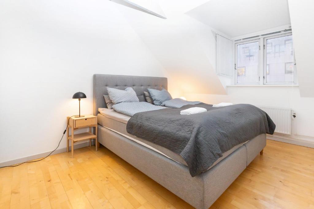 1 dormitorio con 1 cama grande en una habitación blanca en Come Stay in An oasis of life, comfort & style, en Aarhus