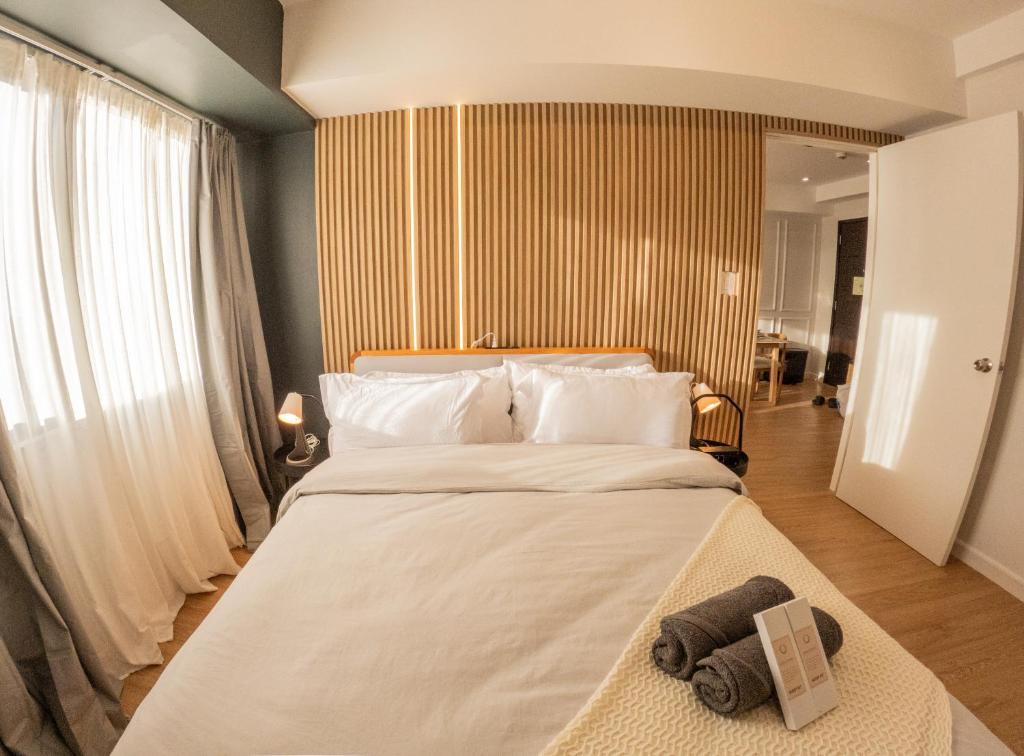 ein Schlafzimmer mit einem großen Bett, auf dem Handtücher liegen in der Unterkunft The Cabin Tagaytay City by John Morales in Tagaytay