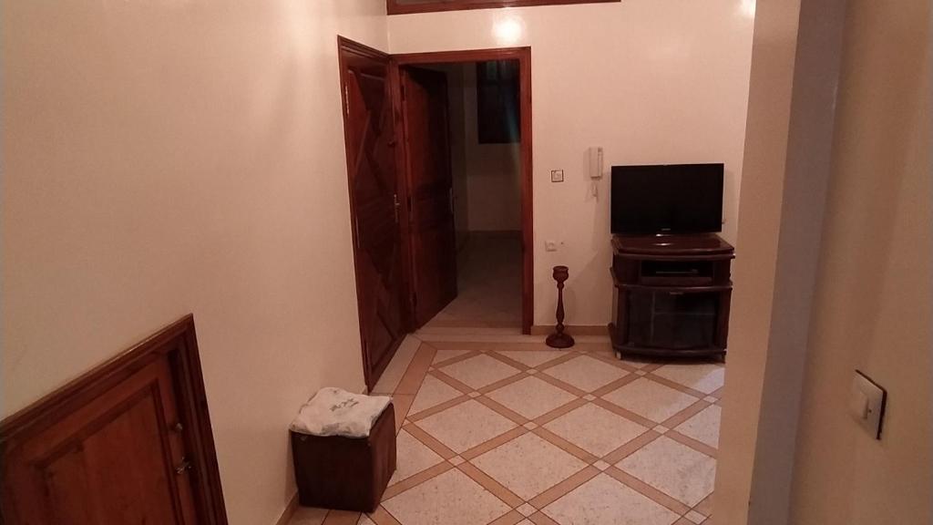 um corredor com um quarto com uma televisão e um átrio com uma secretária em Appartement meublé em Meknès