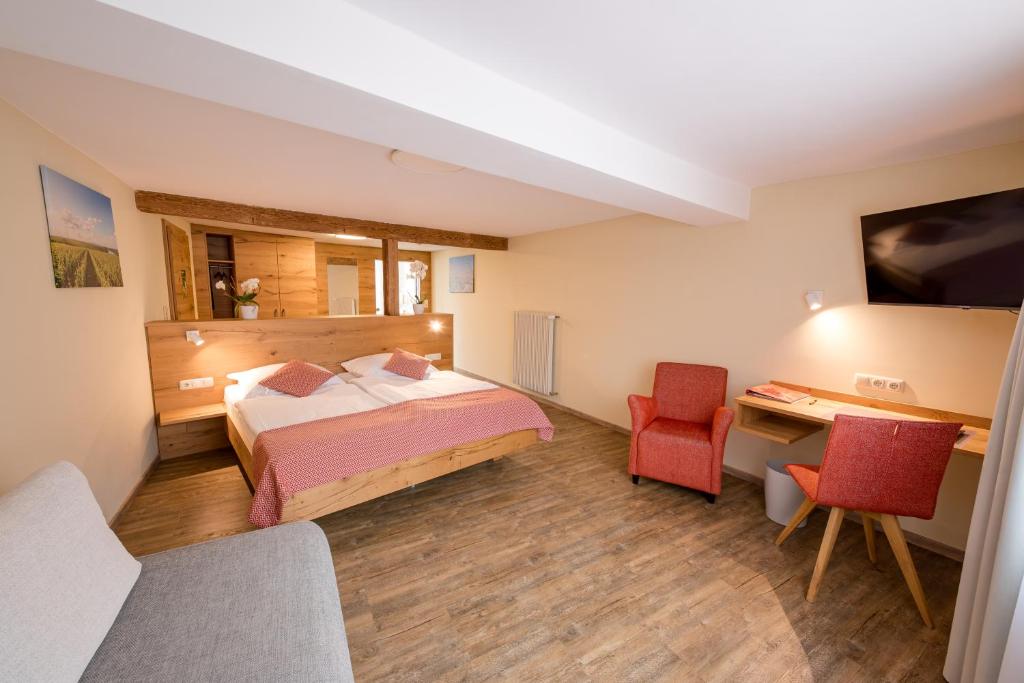 una camera d'albergo con letto e scrivania di Gästehaus Julianenhof a Nierstein