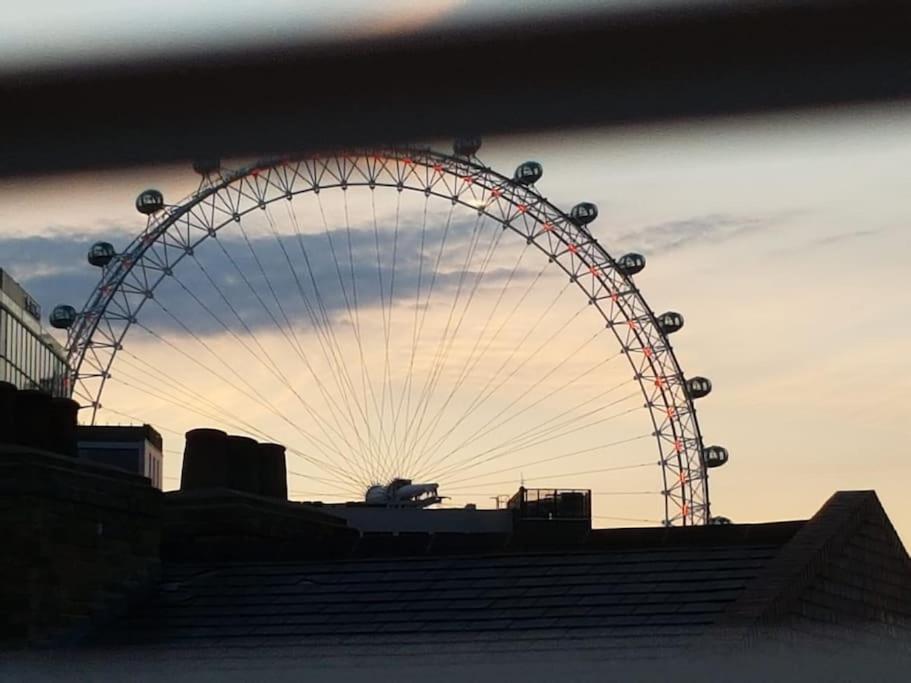a large ferris wheel in a city at sunset at Superb 2Bed/2Bath Flat Waterloo London in London