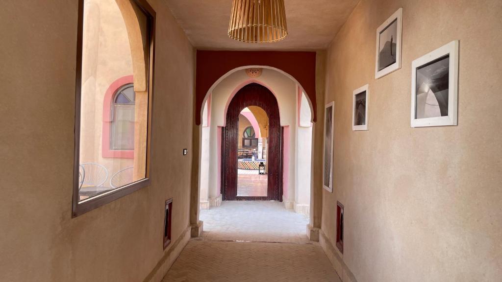梅爾祖卡的住宿－RIAD dar POUBLANC，走廊上设有拱门,通往门